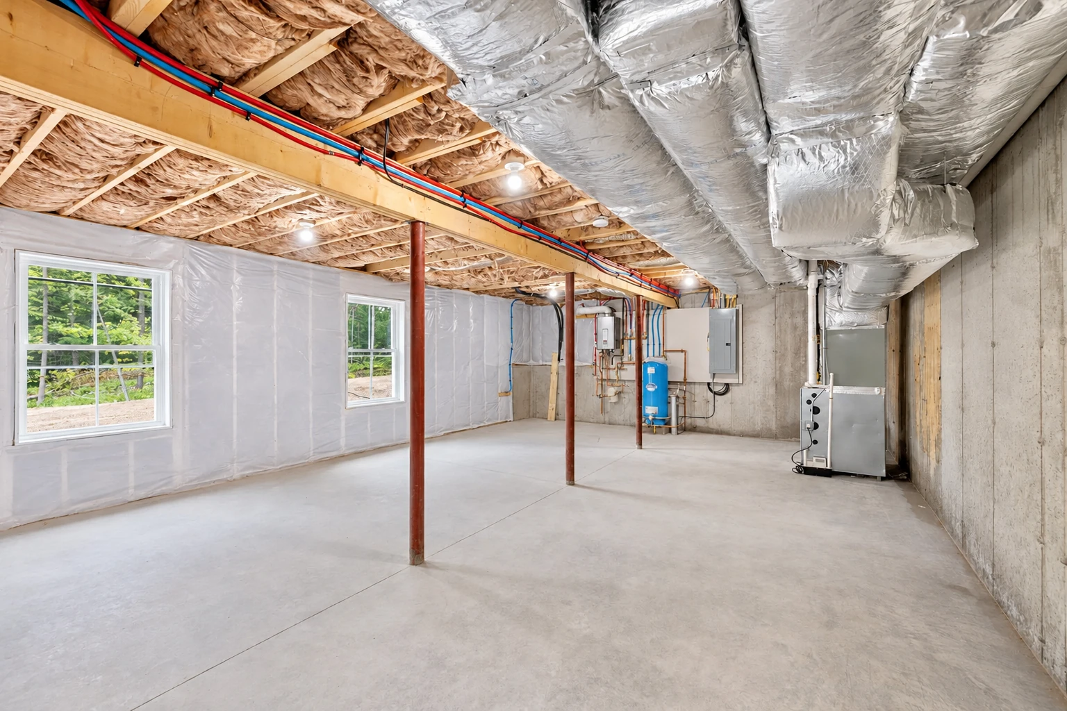 Finished basement with insulated ceiling joists, large silver ducts, plastic-covered walls, and a concrete floor.